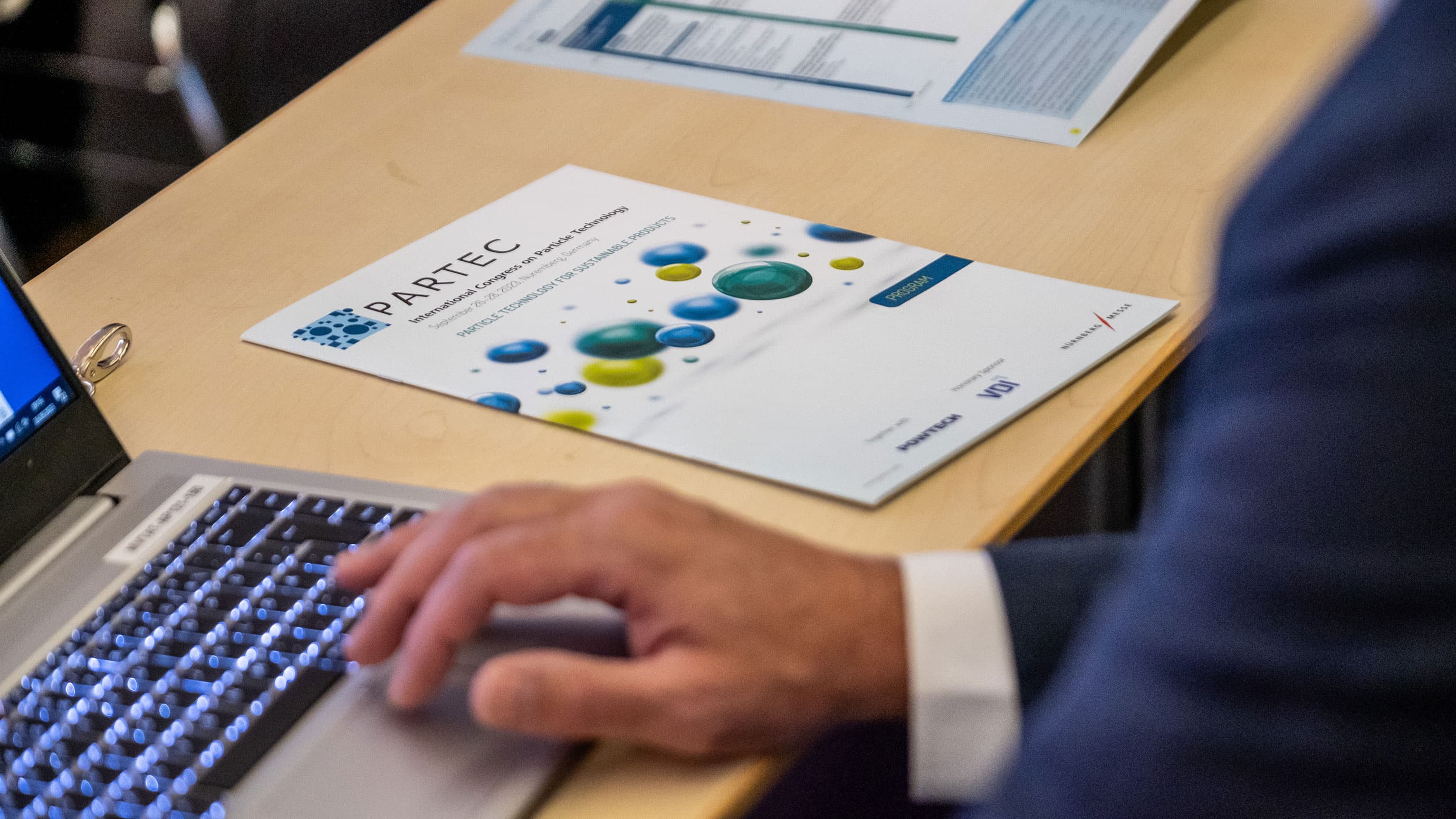 A man working on his laptop beside of a PARTEC Flyer